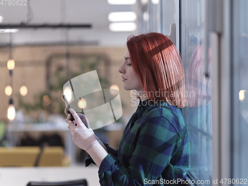 Image of redhead business woman at office using smart phone