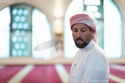 Image of a Muslim ends a prayer by turning his head to the side,.