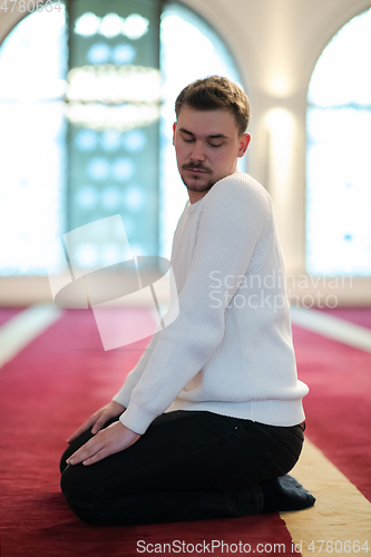 Image of a Muslim ends a prayer by turning his head to the side,.