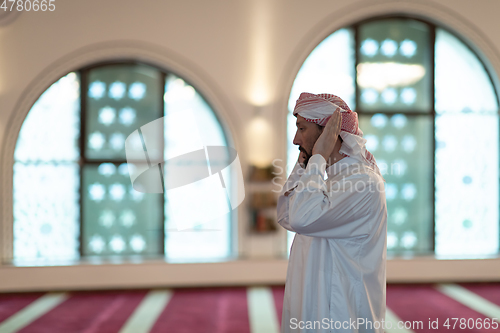 Image of a Muslim begins to offer prayer by raising his hands in the air, a calm state in prayer.