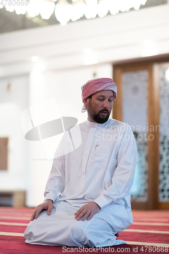 Image of a Muslim ends a prayer by turning his head to the side,.