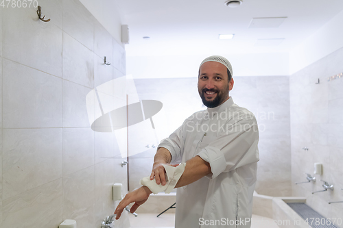 Image of a portrait of a man in abdesthana using a towel