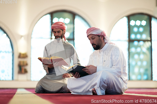 Image of two muslim people in mosque reading quran together concept of islamic education