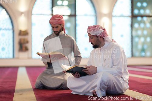 Image of two muslim people in mosque reading quran together concept of islamic education