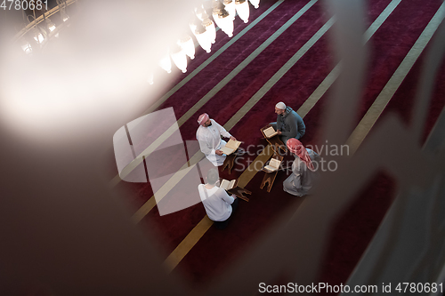 Image of muslim people in mosque reading quran together