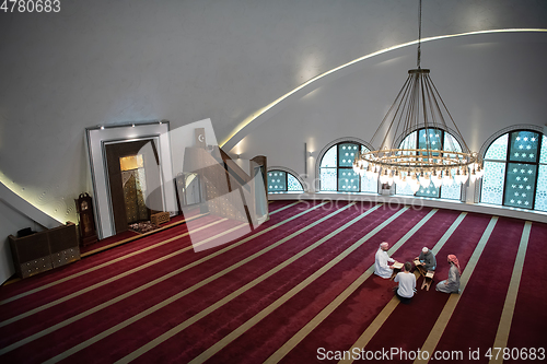 Image of muslim people in mosque reading quran together