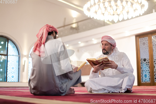 Image of two muslim people in mosque reading quran together concept of islamic education