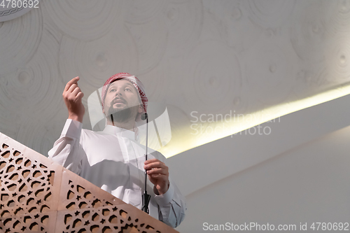 Image of Muslims young arabic Imam has a speech on friday afternoon prayer in mosque.