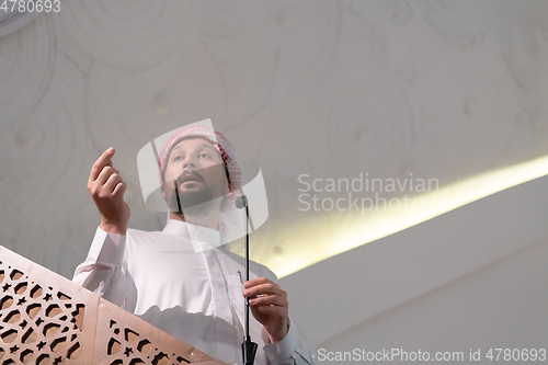 Image of Muslims young arabic Imam has a speech on friday afternoon prayer in mosque.