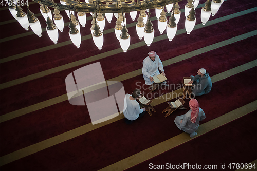 Image of muslim people in mosque reading quran together