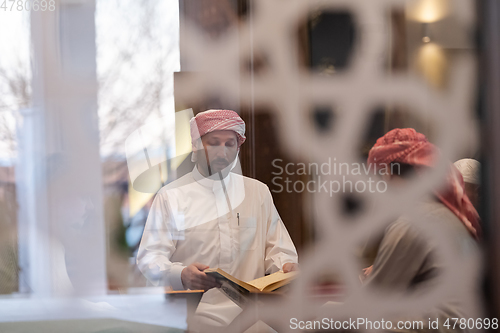 Image of muslim people in mosque reading quran together