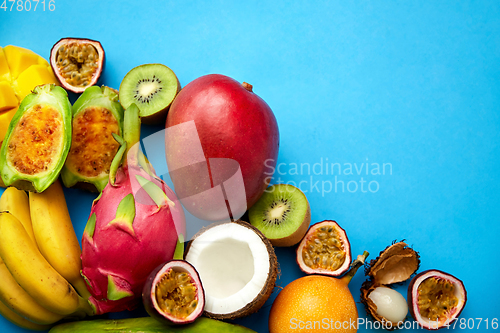 Image of different exotic fruits on blue background