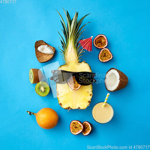 Image of pineapple in sunglasses with other exotic fruits