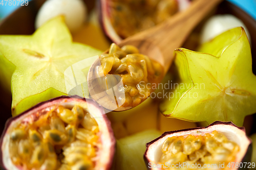 Image of close up of of exotic fruits mix with wooden spoon