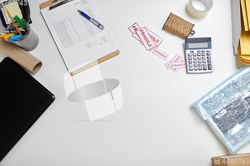 Image of calculator, clipboard and envelopes at post office