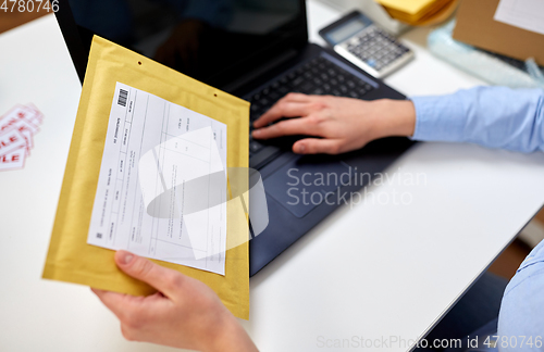 Image of hands with laptop and envelope at post office