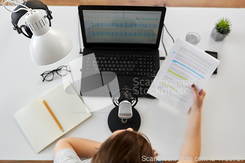 Image of woman with microphone recording podcast at studio