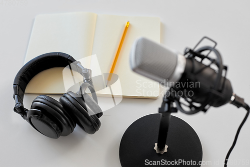 Image of headphones, microphone and notebook with pencil