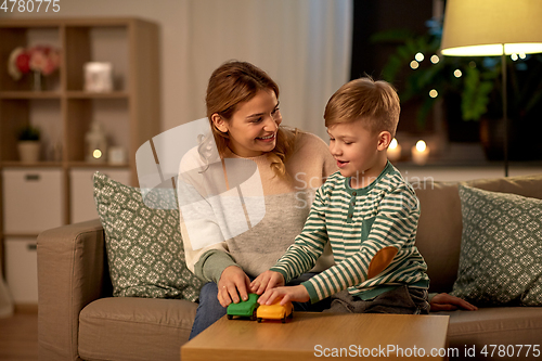 Image of mother and son playing with toy cars at home