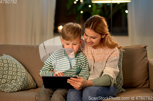 Image of mother and son using tablet computer at home