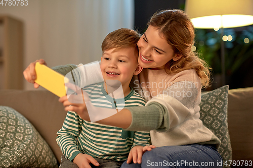 Image of mother and son taking selfie by smartphone at home