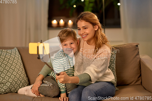 Image of mother and son taking selfie by smartphone at home