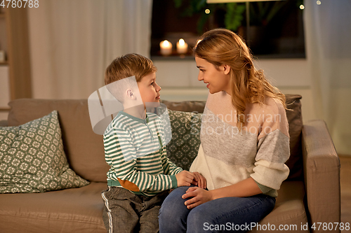 Image of happy smiling mother talking to her son at home