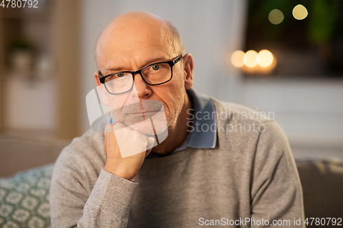 Image of sad senior man in glasses thinking at home