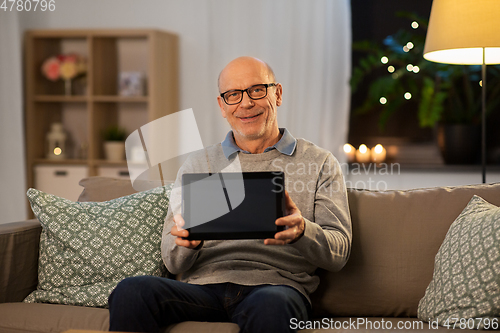 Image of happy senior man with tablet computer at home