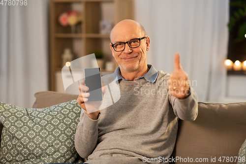 Image of happy senior man with smartphone at home