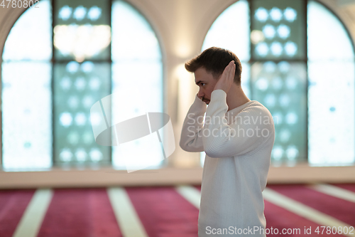 Image of a Muslim begins to offer prayer by raising his hands in the air, a calm state in prayer.