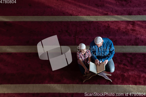 Image of father and son reading holly book quran together islamic education concept