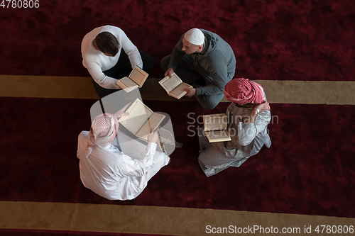 Image of muslim people in mosque reading quran together