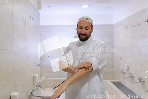 Image of a portrait of a man in abdesthana using a towel