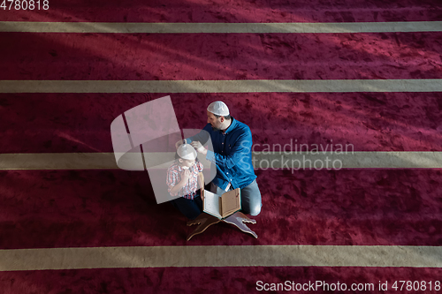 Image of father and son reading holly book quran together islamic education concept