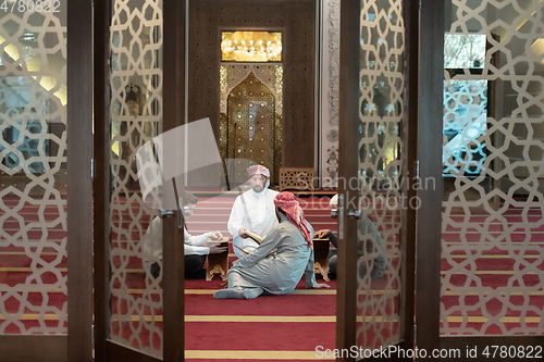 Image of muslim people in mosque reading quran together