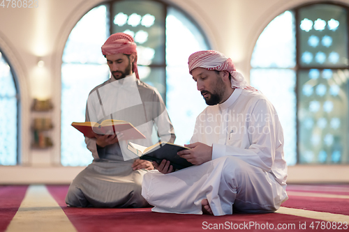 Image of two muslim people in mosque reading quran together concept of islamic education