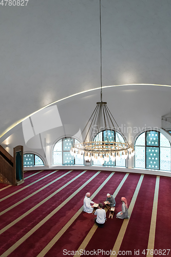 Image of muslim people in mosque reading quran together