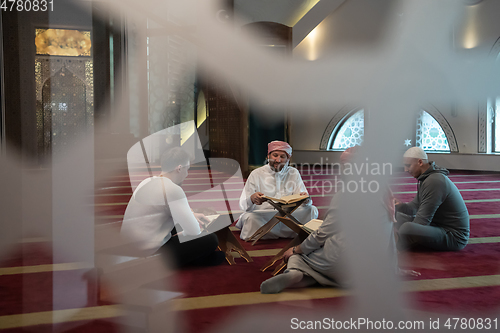 Image of muslim people in mosque reading quran together