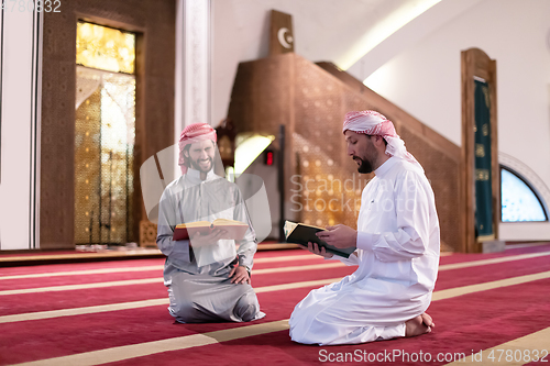 Image of two muslim people in mosque reading quran together concept of islamic education