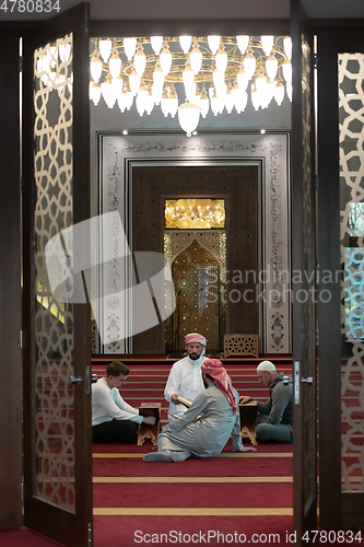 Image of muslim people in mosque reading quran together