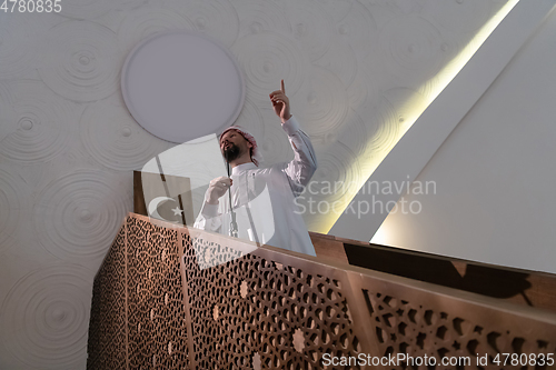 Image of Muslims young arabic Imam has a speech on friday afternoon prayer in mosque.