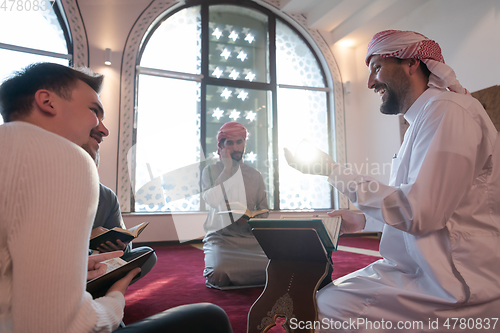 Image of muslim people in mosque reading quran together