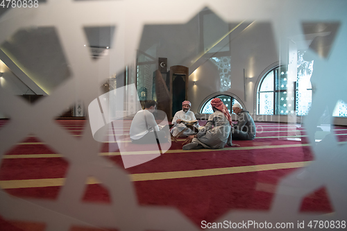 Image of muslim people in mosque reading quran together