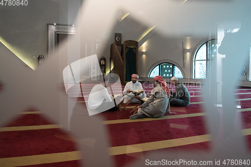 Image of muslim people in mosque reading quran together