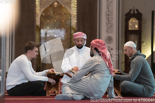 Image of muslim people in mosque reading quran together