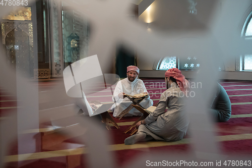 Image of muslim people in mosque reading quran together