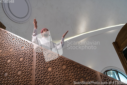 Image of Muslims young arabic Imam has a speech on friday afternoon prayer in mosque.