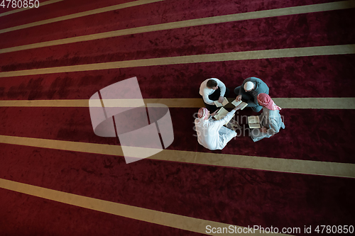 Image of muslim people in mosque reading quran together