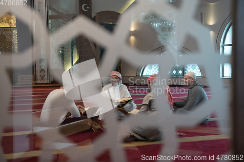 Image of muslim people in mosque reading quran together